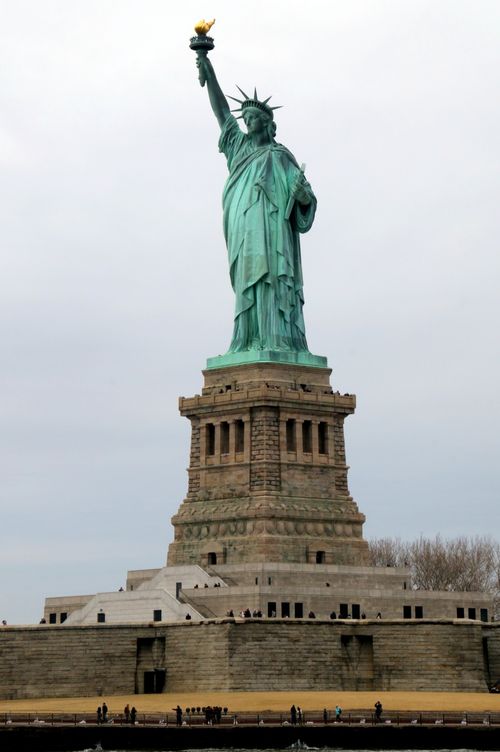 Free Iconic Statue of Liberty in New York City under cloudy skies, USA. Stock Photo