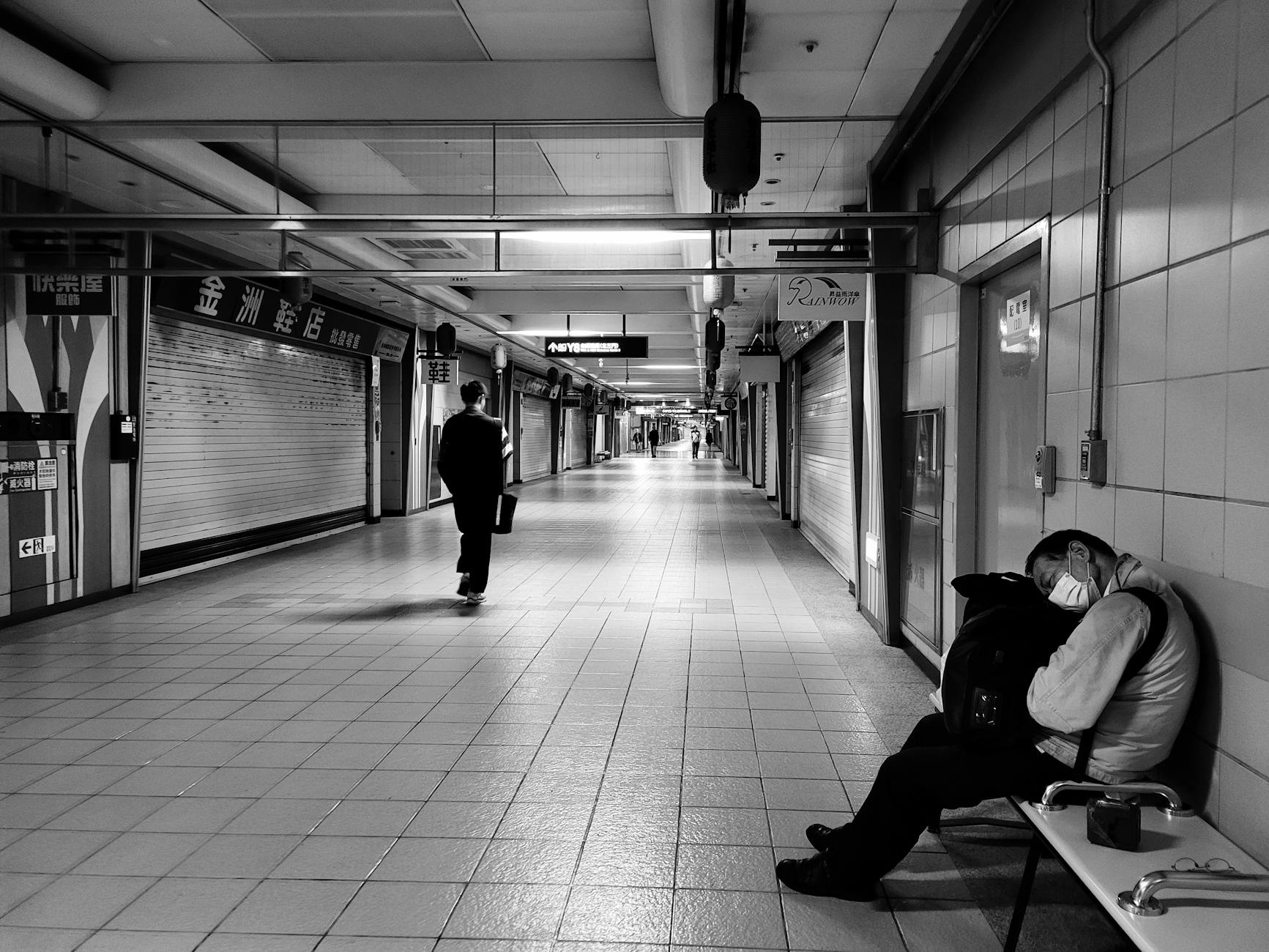 A man sitting on a bench in a subway station