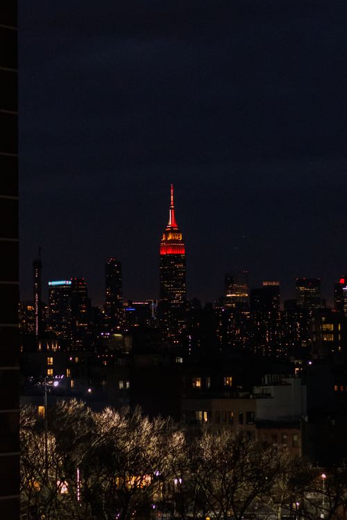 Free A stunning night view of the New York City skyline with the Empire State Building prominently lit. Stock Photo