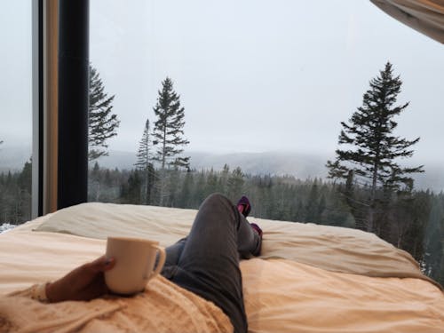 Woman drinking coffee and looking at the forest