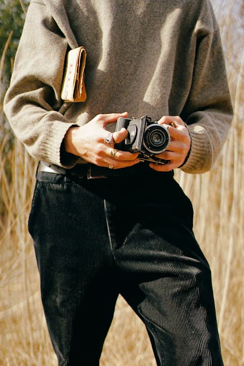 Darmowe zdjęcie z galerii z aparat analogowy, czarne spodnie, fotografia mody