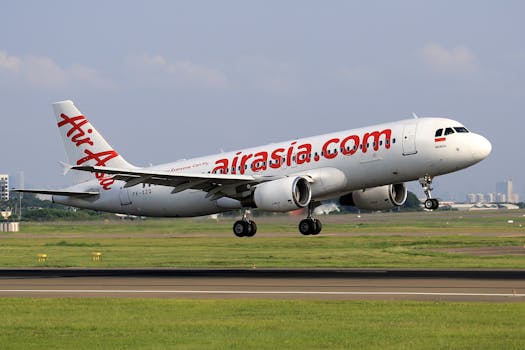 AirAsia Airbus A320 captured taking off from a busy airport runway on a clear day.