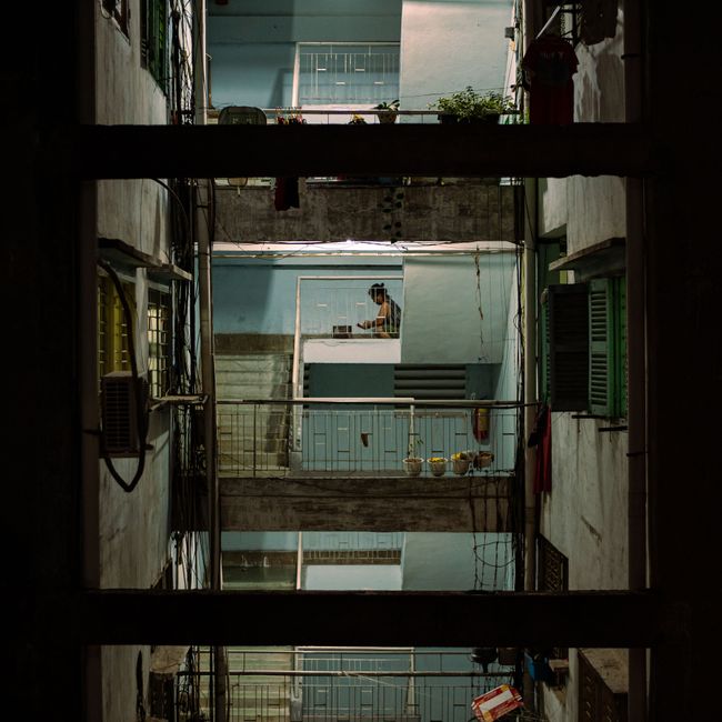 View of a multi-story urban building interior, showcasing railings and balconies at night.