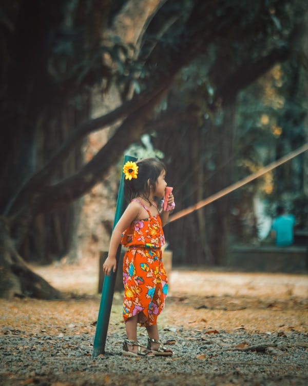 Girl Wearing Orange Floral Jumpsuit