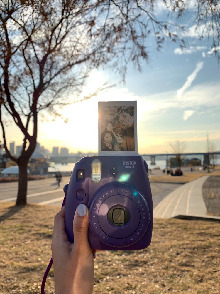 Person Holding Purple Fujifilm Instax Camera With Photo