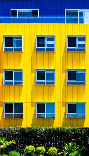 Colorful yellow and blue facade of a modern urban residential building.