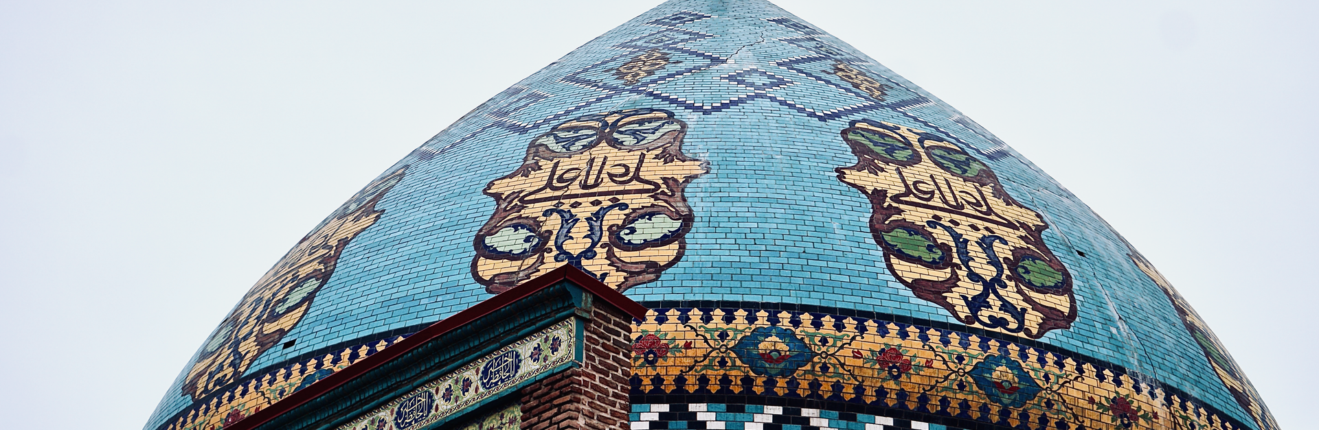 Close-up of an elaborate blue mosque dome showcasing intricate geometric patterns and artistry.