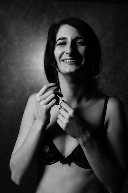 A woman in lingerie smiling while holding a toothbrush