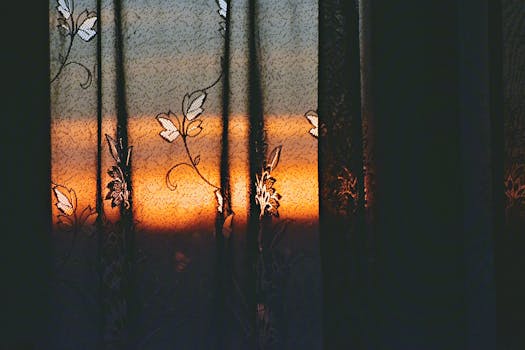 优雅的窗帘映出生动的日落，营造出戏剧而艺术的氛围