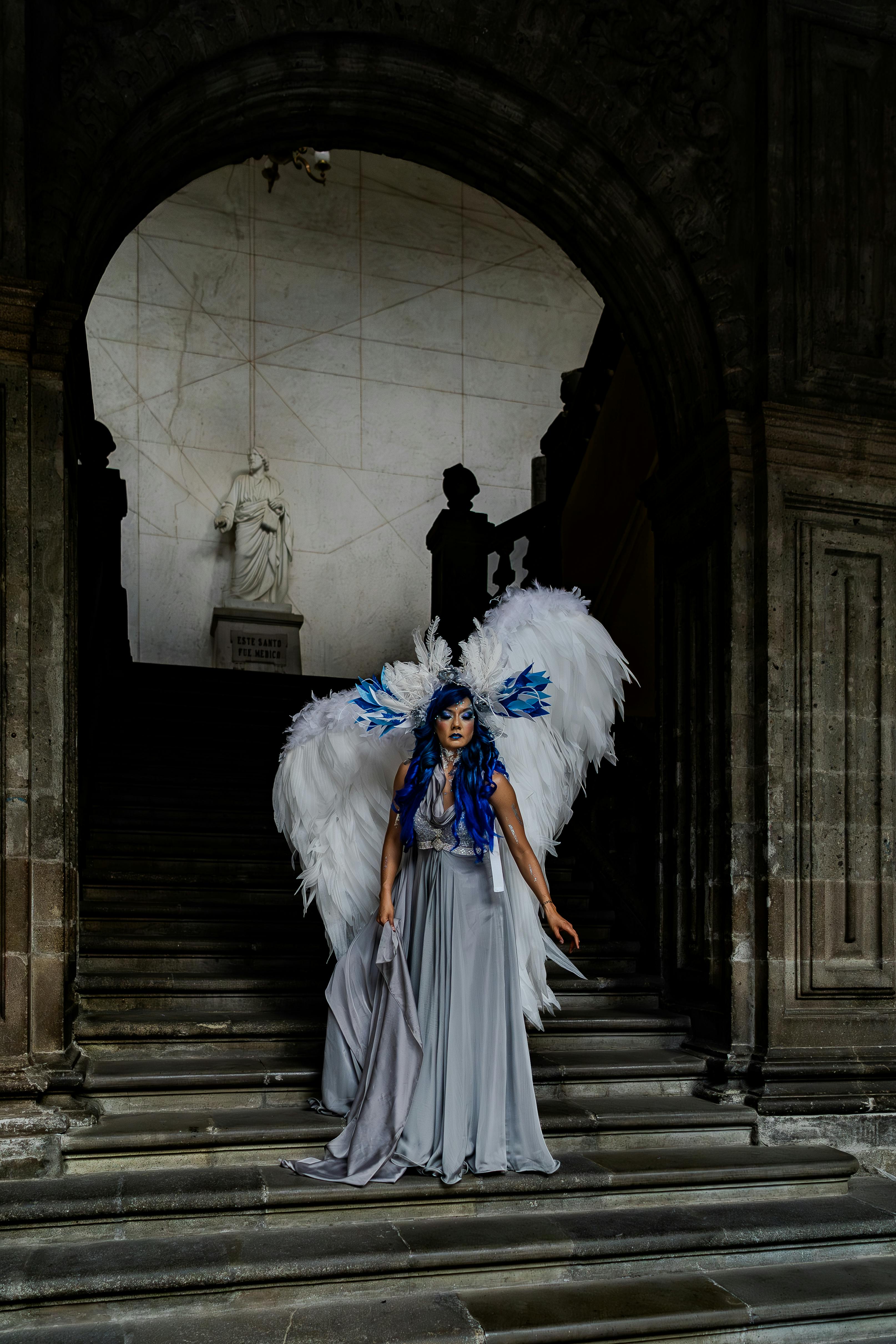 Woman in angel costume with wings in a historic Mexican building.