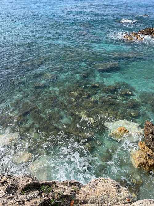 Free A stunning aerial view of a rocky coastline with clear blue water and gentle waves. Stock Photo