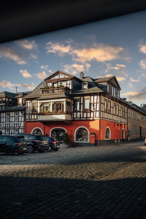 Free Picturesque old town scene with a half-timbered house under a vivid sunset sky. Stock Photo