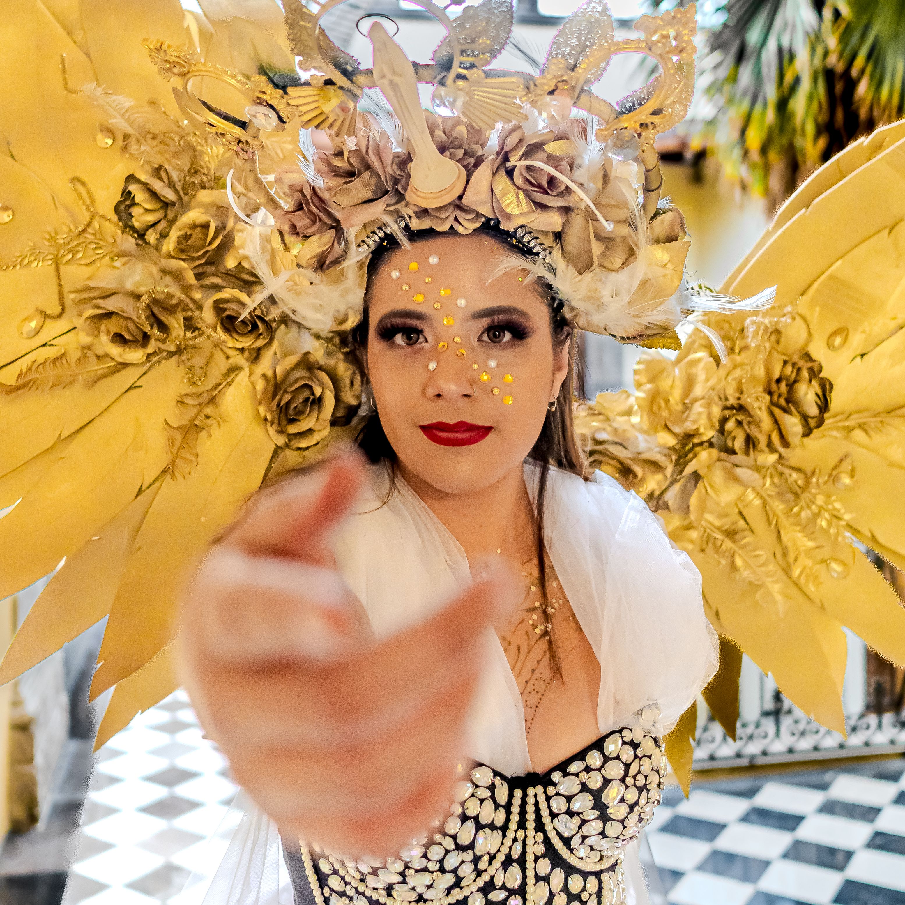 A majestic female in golden angelic attire, captured in an artistic and elegant portrait.