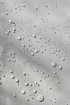 Detailed image of water droplets on a smooth surface, showcasing patterns and textures.