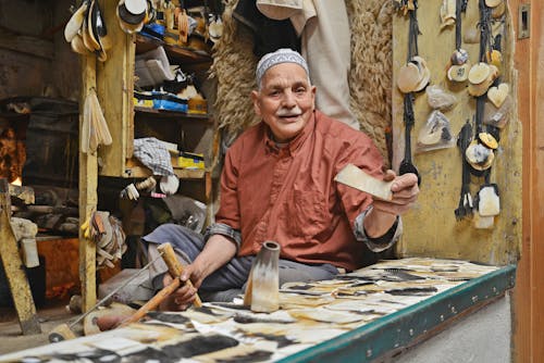An Artisan Sitting in His Shop Surrounded with Handmade Items 