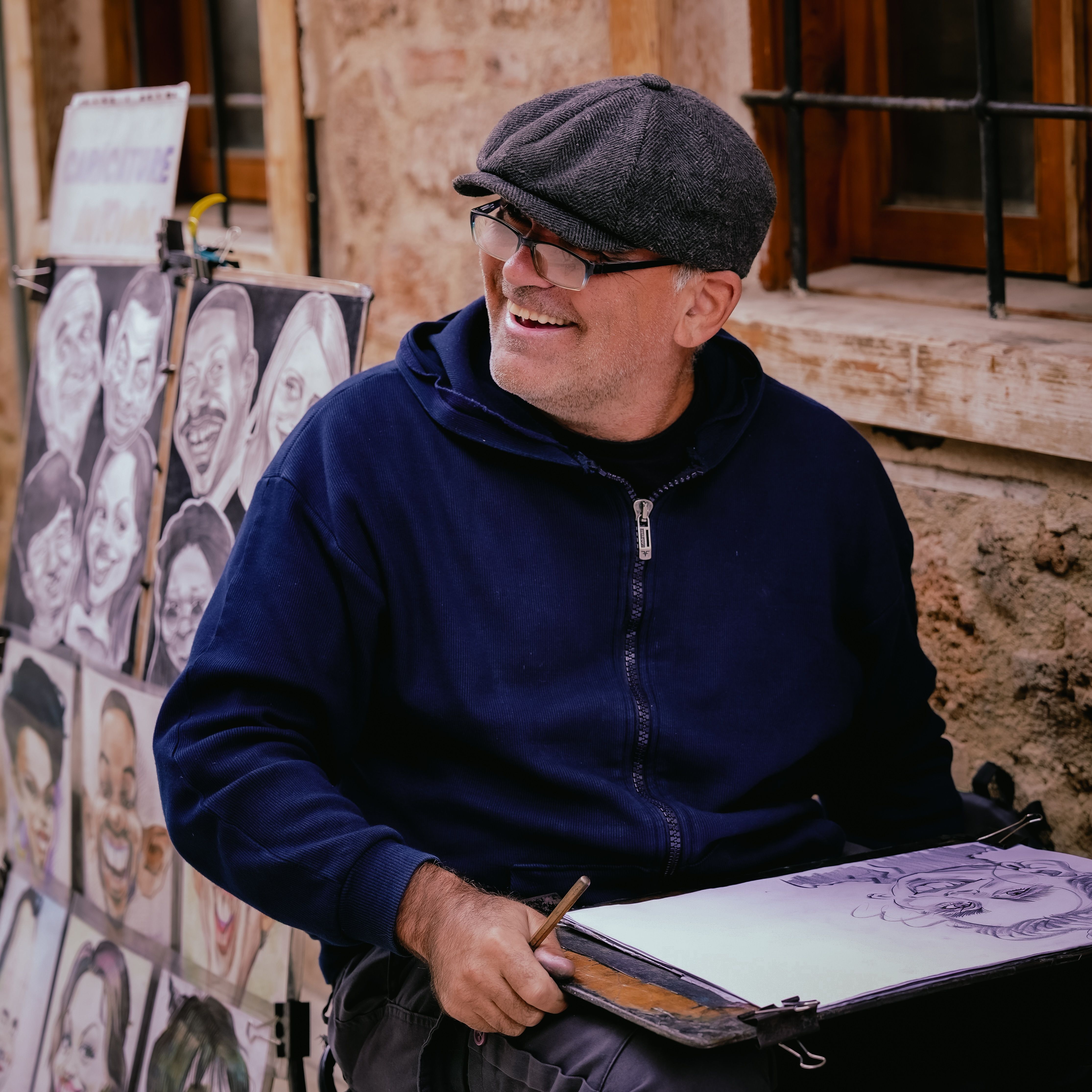 Smiling Street Artist Sitting and Drawing