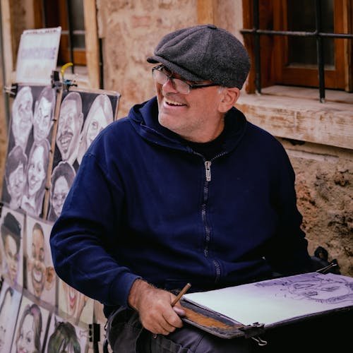 A man is smiling while drawing on a piece of paper