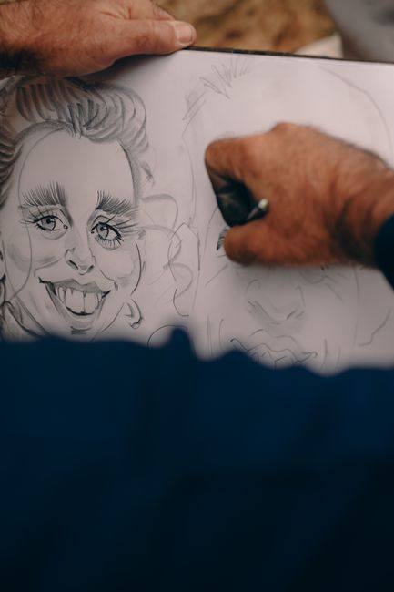 Fotomural Primer plano de manos dibujando caricaturas en papel, capturando la creatividad artística.