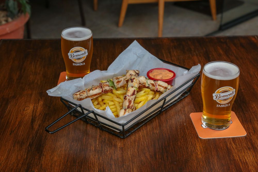 Masă la restaurant cu două beri și mâncare belgiană