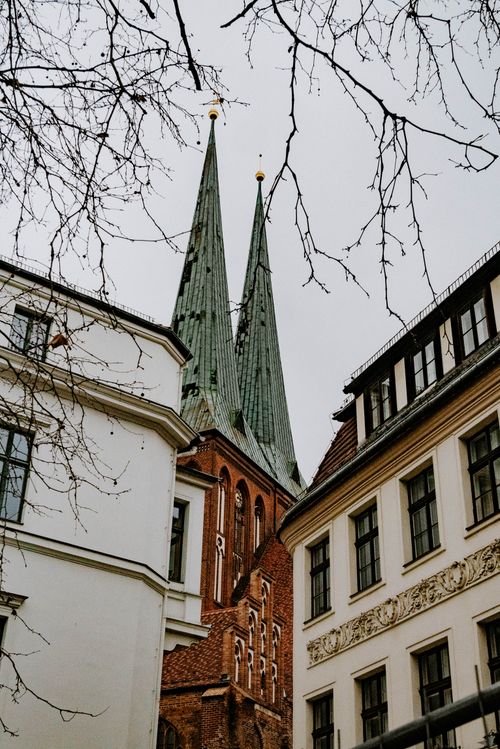 Free View of Gothic church spires framed by city buildings, showcasing Riga architecture. Stock Photo