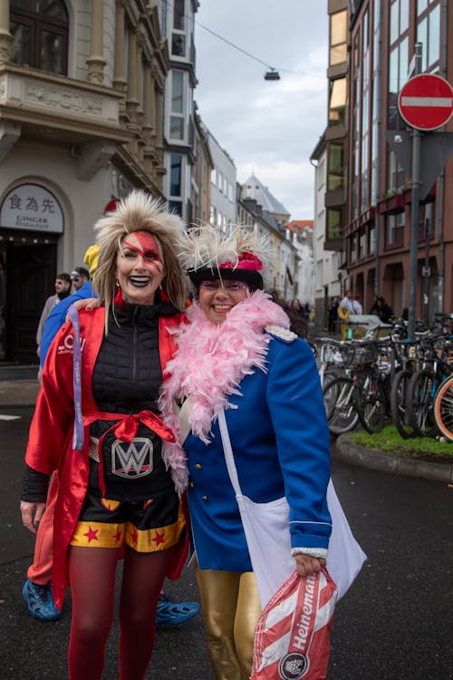 Two women dressed in costumes standing on a street