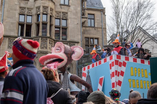 Vivid scene from Cologne Carnival parade featuring monkey float and costumed crowd.