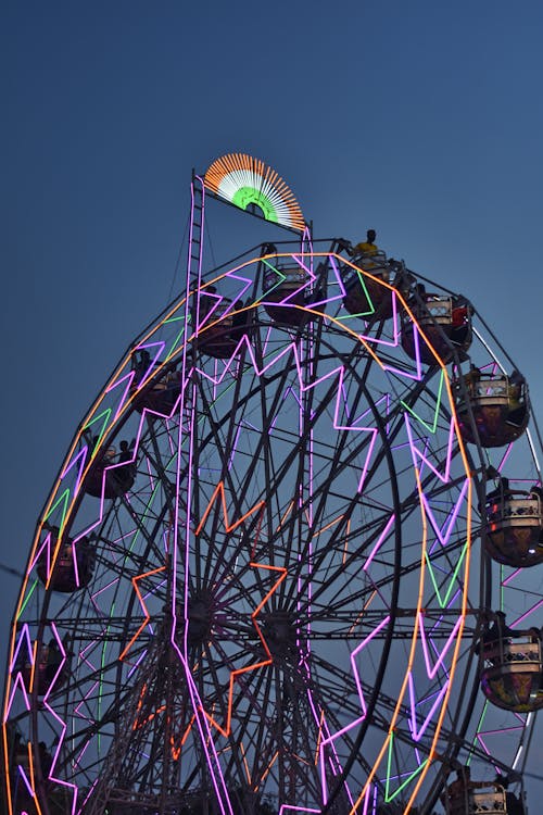 A ferris wheel with a colorful light on it