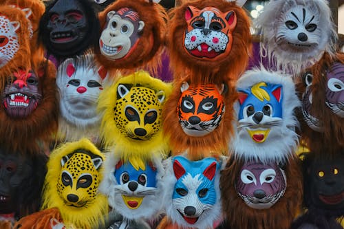 A group of colorful masks are displayed on a wall