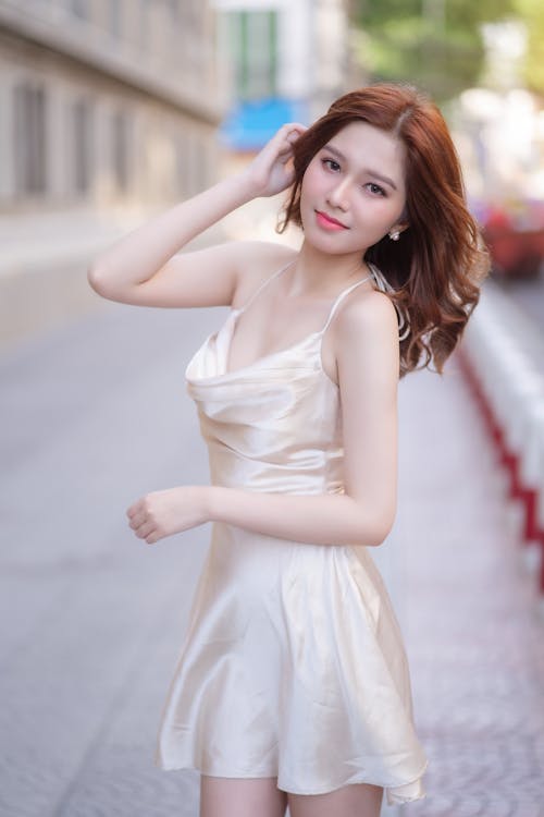 A woman in a white dress posing for the camera