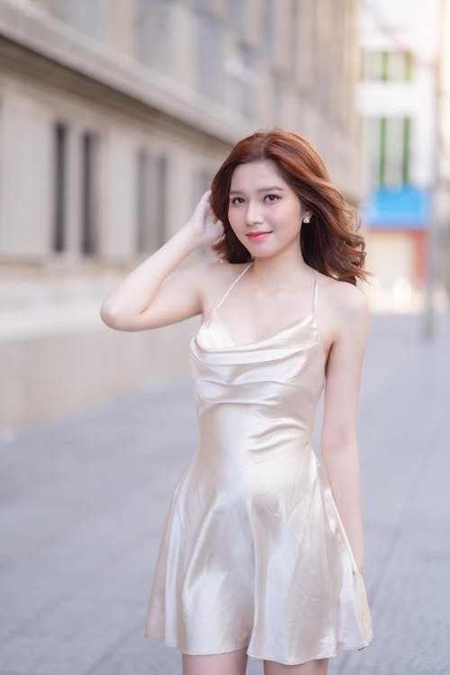 A woman in a gold dress posing for a photo