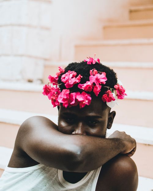 Free Stylish portrait of a man wearing a flower crown shot outdoors in Mombasa. Stock Photo