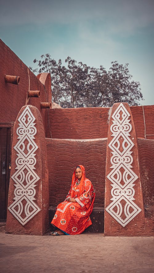 Woman Sitting in Traditional Clothing in Village
