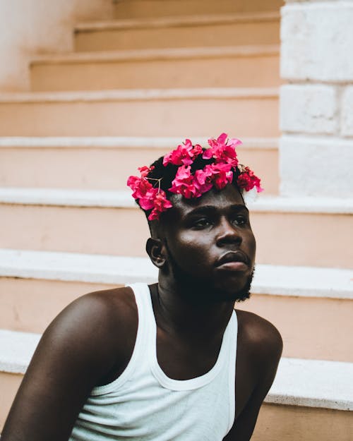 Photo of Man in Floral Headband Sitting on Stairs