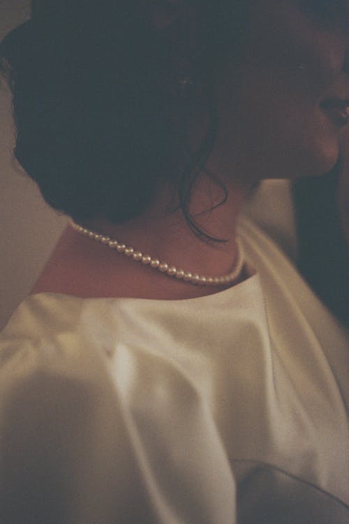 A close up of a woman wearing a pearl necklace
