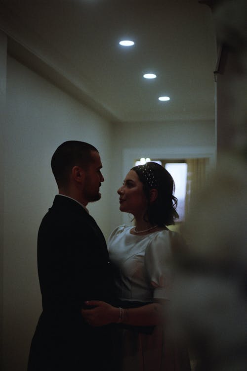 A bride and groom are standing in a hallway