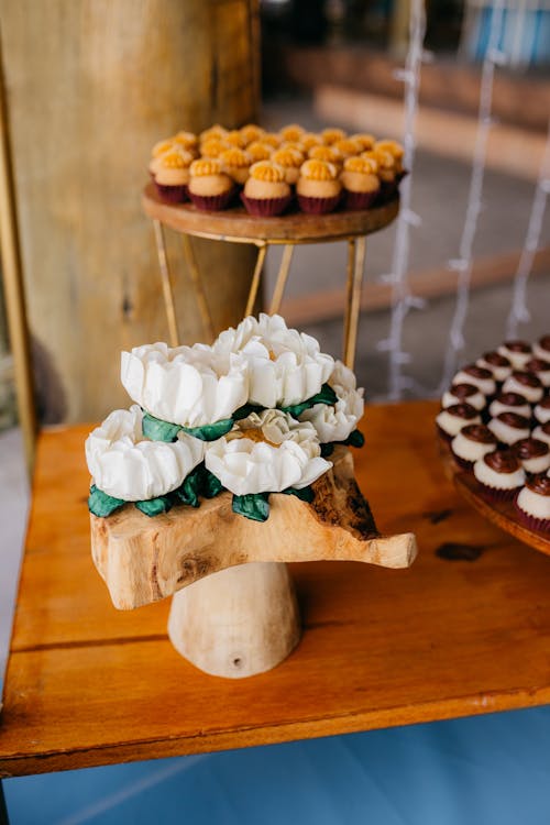 A wooden table with cupcakes and desserts