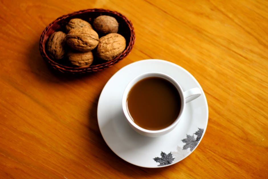 A serene setup with a cup of coffee and walnuts in a basket on a wooden table.
