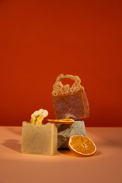 Orange and lemon soap on a table with a red background