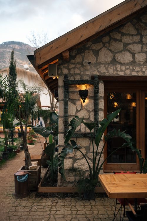 Free Charming rustic stone house with lush garden plants and ambient lighting. Stock Photo