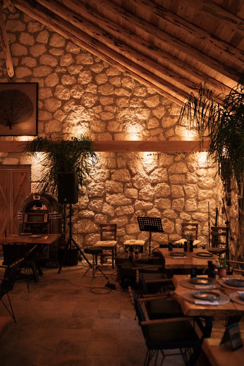 A restaurant with a stone wall and wooden tables