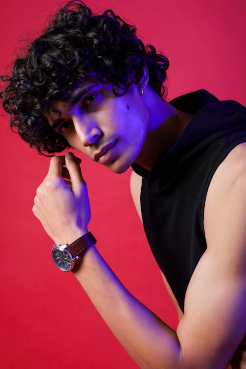 A young man with curly hair wearing a watch