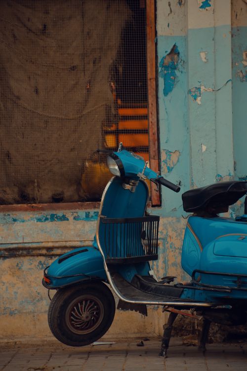 Free A vintage blue scooter parked against a rustic wall in Karachi's urban landscape. Stock Photo