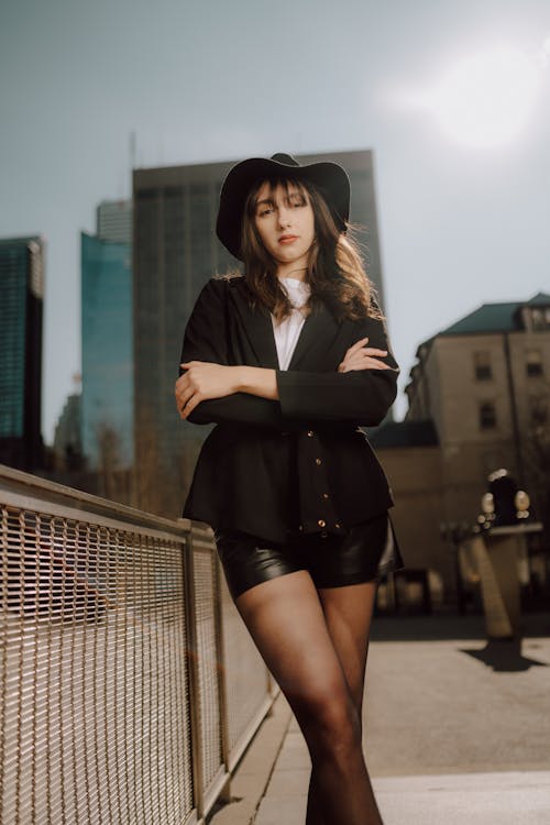 A woman in black shorts and a hat posing for a photo