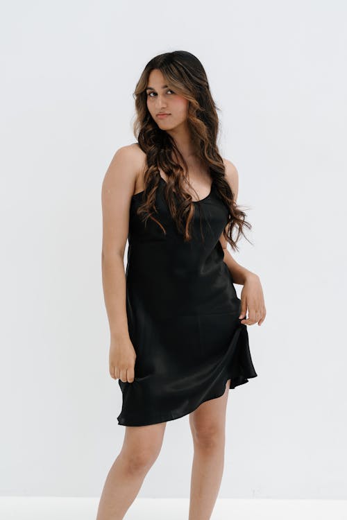The model is wearing a black slip dress