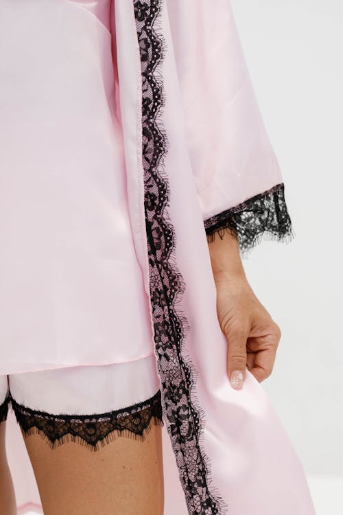 A woman in pink robe and black lace underwear