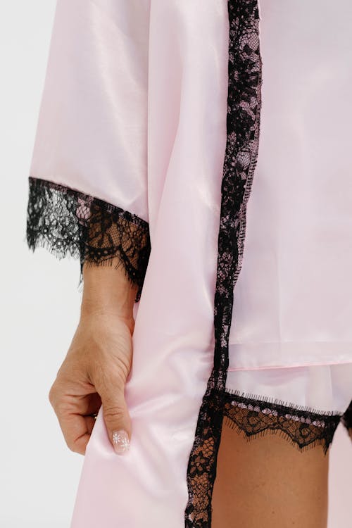 The pink robe is made with lace and has a black trim