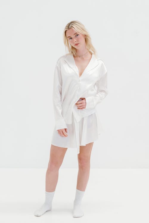 The model is wearing a white shirt and shorts