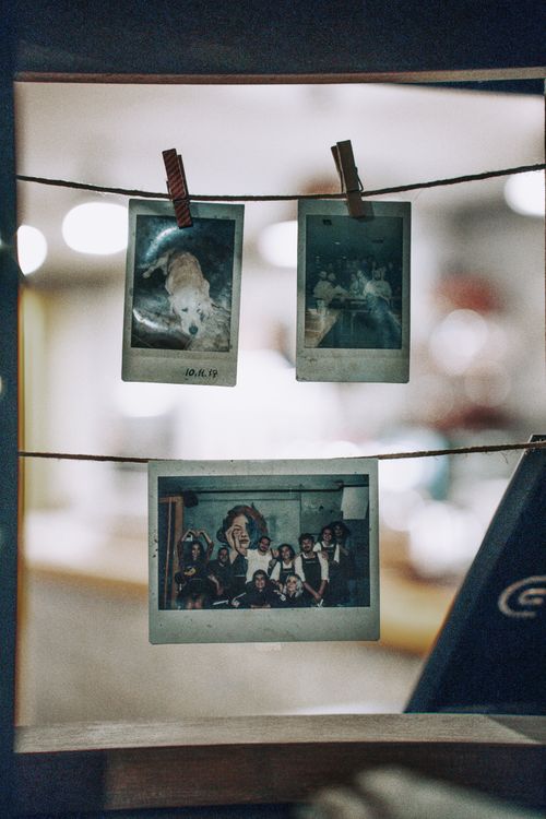 Free Three nostalgic Polaroid photos pegged to a string with blurred interior background. Stock Photo