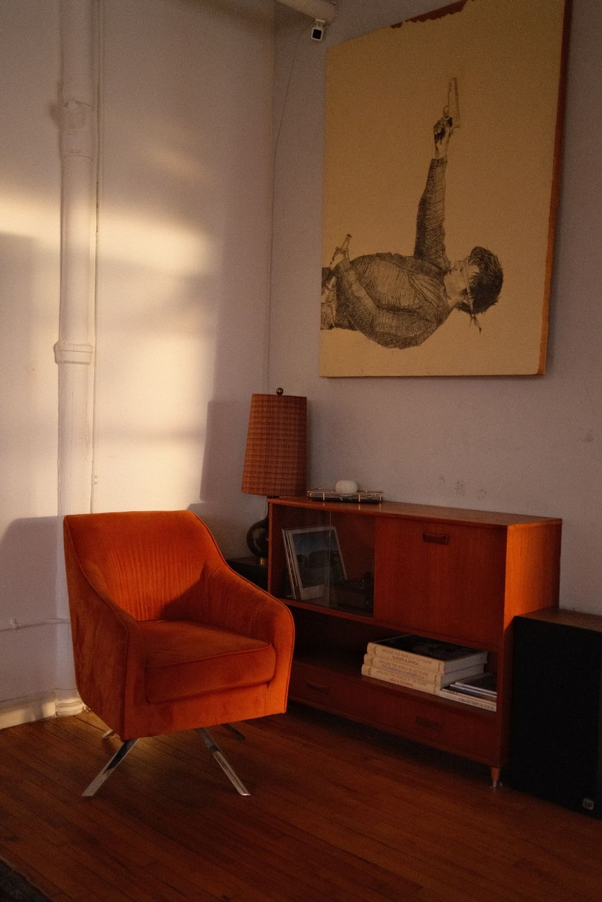 Mid-century modern living room with orange armchair and art piece.. century, modern, living