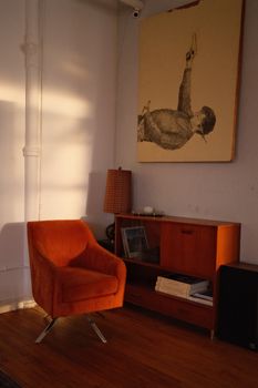 Mid-century modern living room with orange armchair and art piece.. century, modern, living